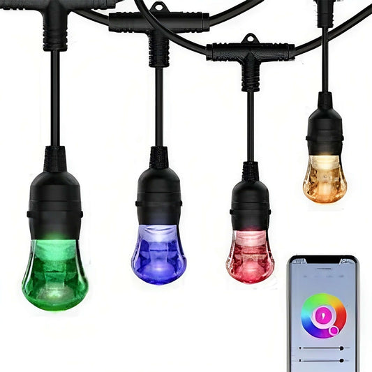 A set of colored smart bulbs in green, blue, and red, hanging from black cords, with one bulb illuminated in amber, controlled by a smartphone app displayed on the right.