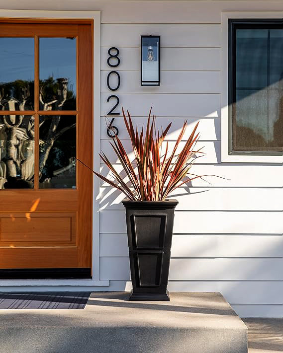 A black planter on the front porch of a home.