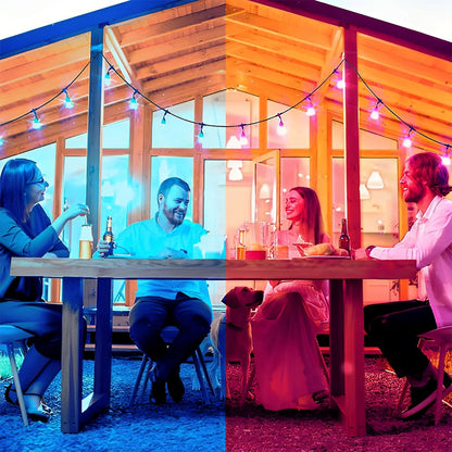 A split image of two couples dining outside under a string of colored lights, with each half bathed in a different colored light: blue on the left and red on the right.