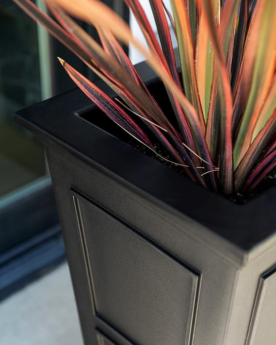 A black planter filled with vibrant, colorful plants, adding a lively touch to any space.