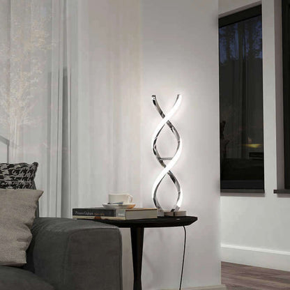 An elegant, helix-shaped floor lamp stands beside a sofa, casting a soft light on a modern living room corner with a side table and books.